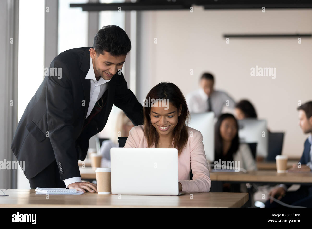Cheerful diverse coworkers working together in coworking area Stock Photo