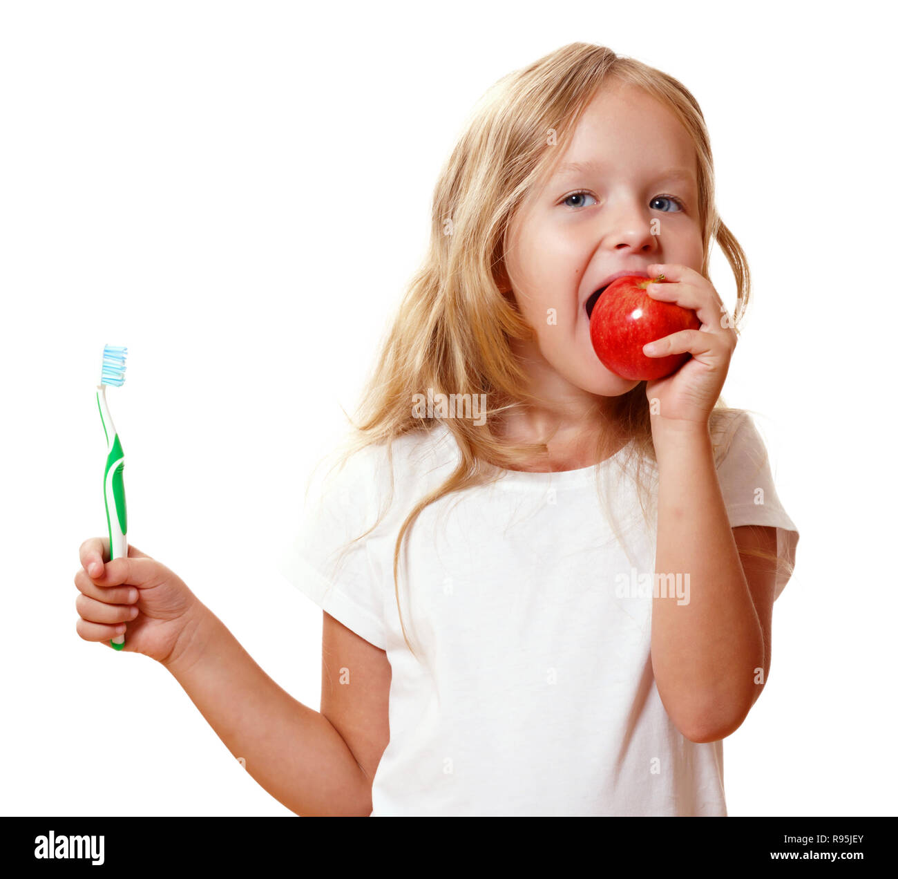 Little girl with a toothbrush and an apple. The concept of daily hygiene. Isolated on white background Stock Photo
