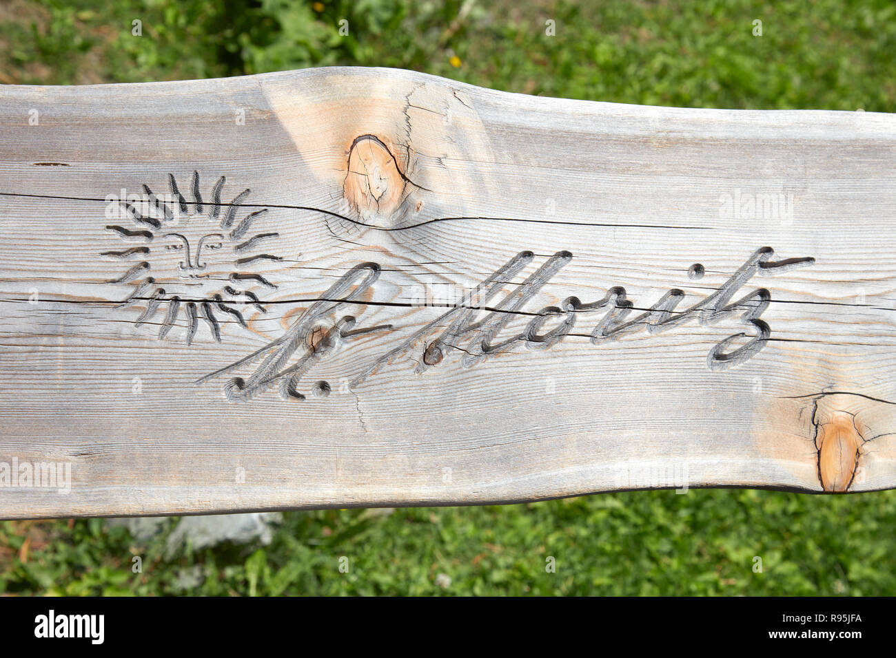 SANKT MORITZ, SWITZERLAND - AUGUST 16, 2018: City logo with sun carved in wooden bench plank in a sunny summer day in Sankt Moritz, Switzerland Stock Photo