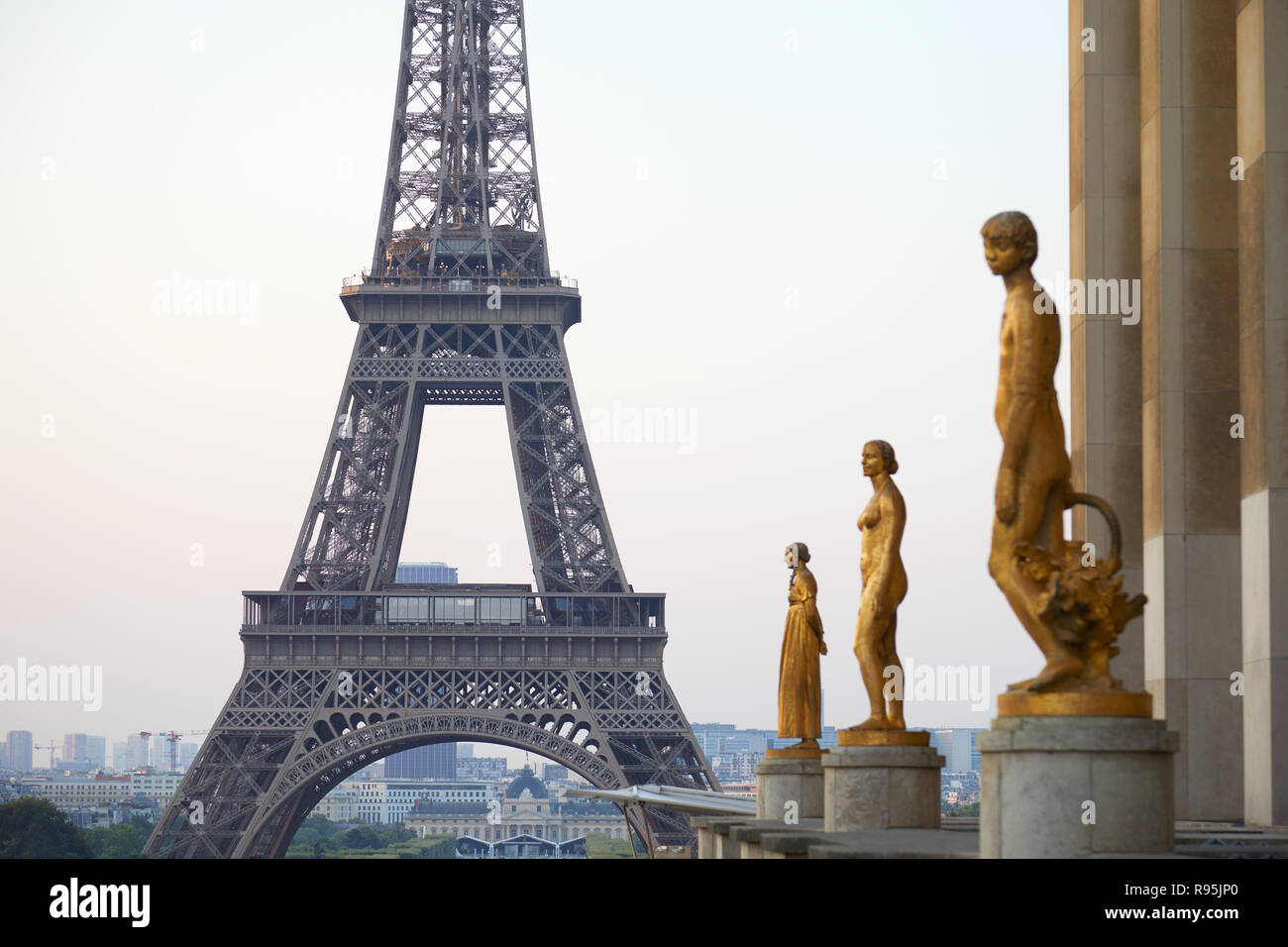 PARIS, FRANCE - JULY 7, 2018: Eiffel tower and golden staues, early morning in Paris, France Stock Photo
