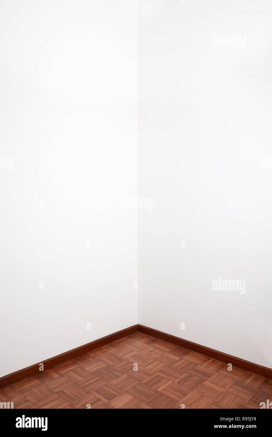 Apartment corner with wooden tiled floor and white blank wall Stock Photo