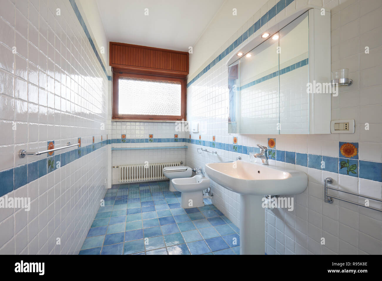 Normal bathroom with blue and white tiles in apartment interior Stock