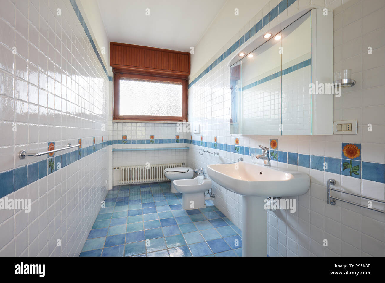 Normal bathroom with blue and white tiles in apartment interior Stock Photo