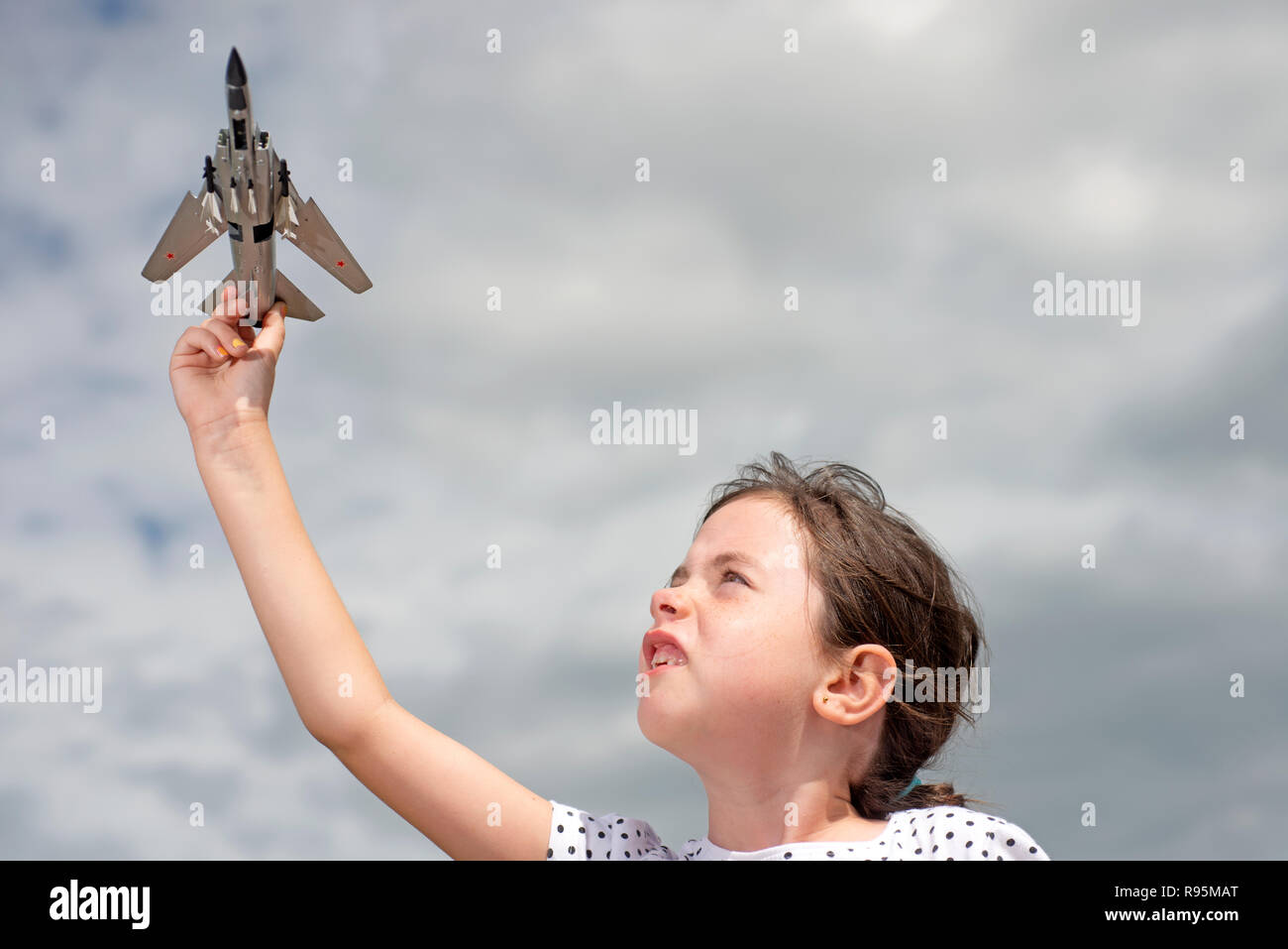 Young girl playing with Russian fighter jet model Stock Photo