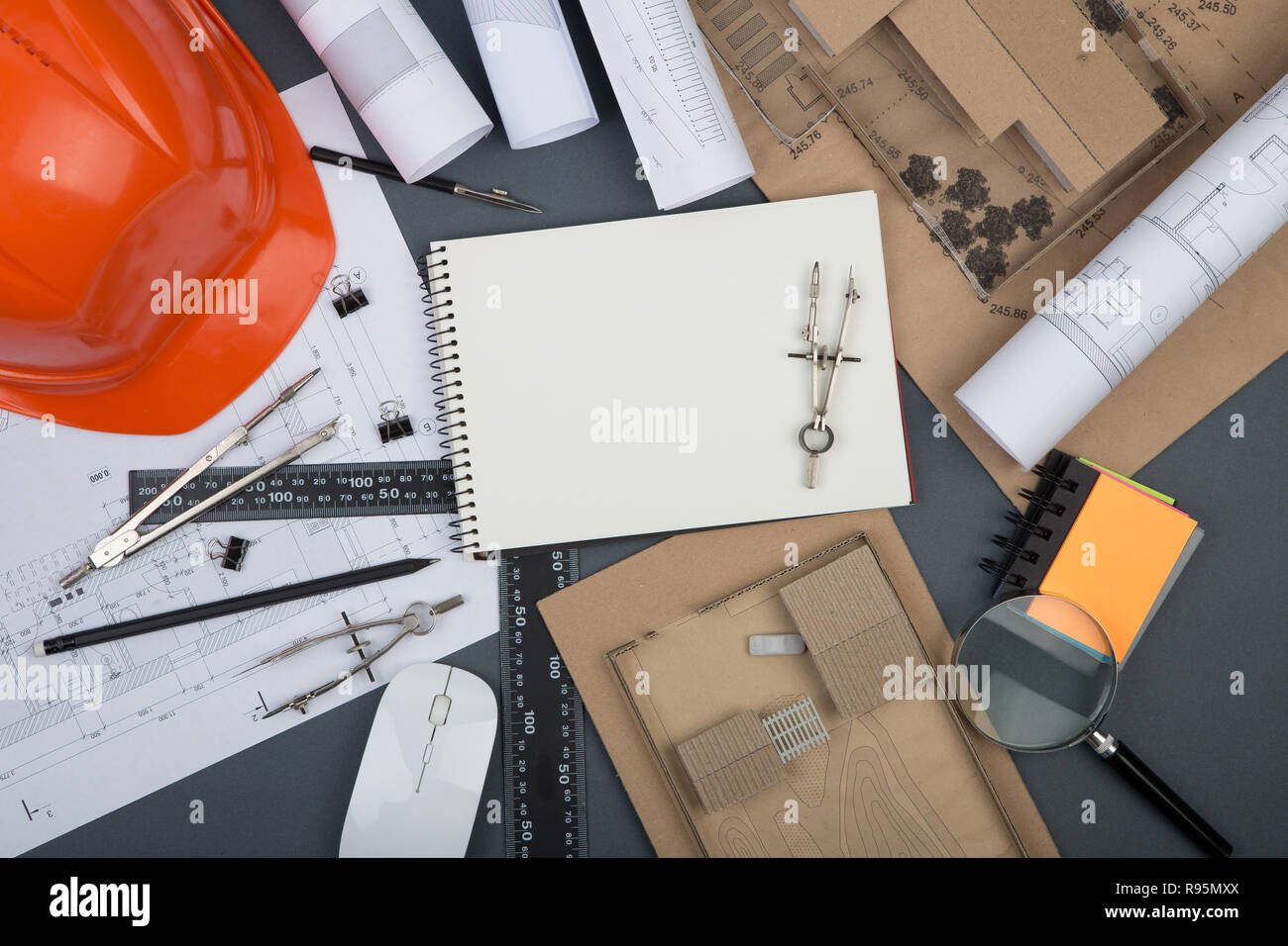 Workplace of architect blank note pad, construction drawings and