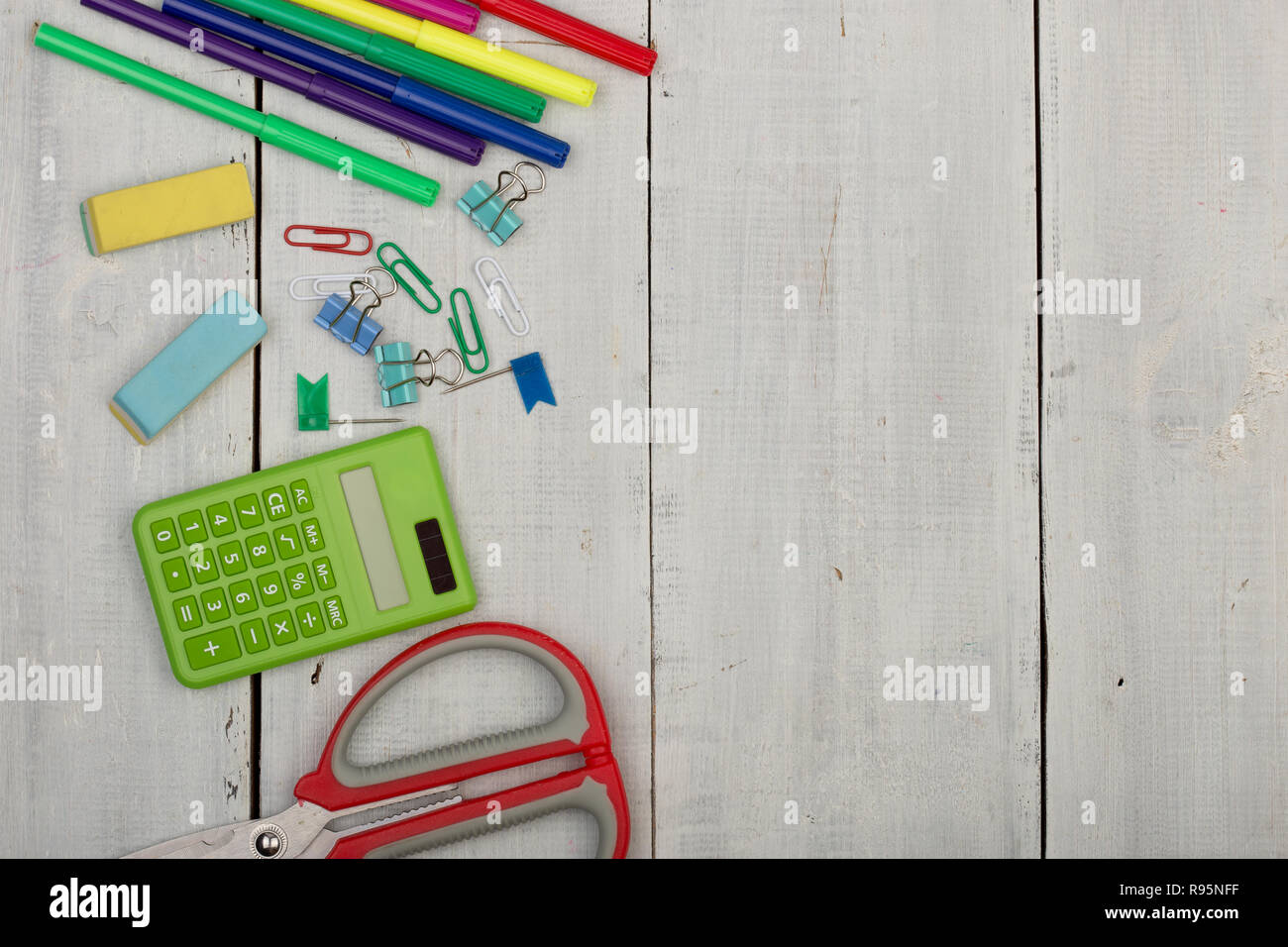 School supplies - scissors, stickers, calculator, eraser, markers and other accessories on white wooden table Stock Photo