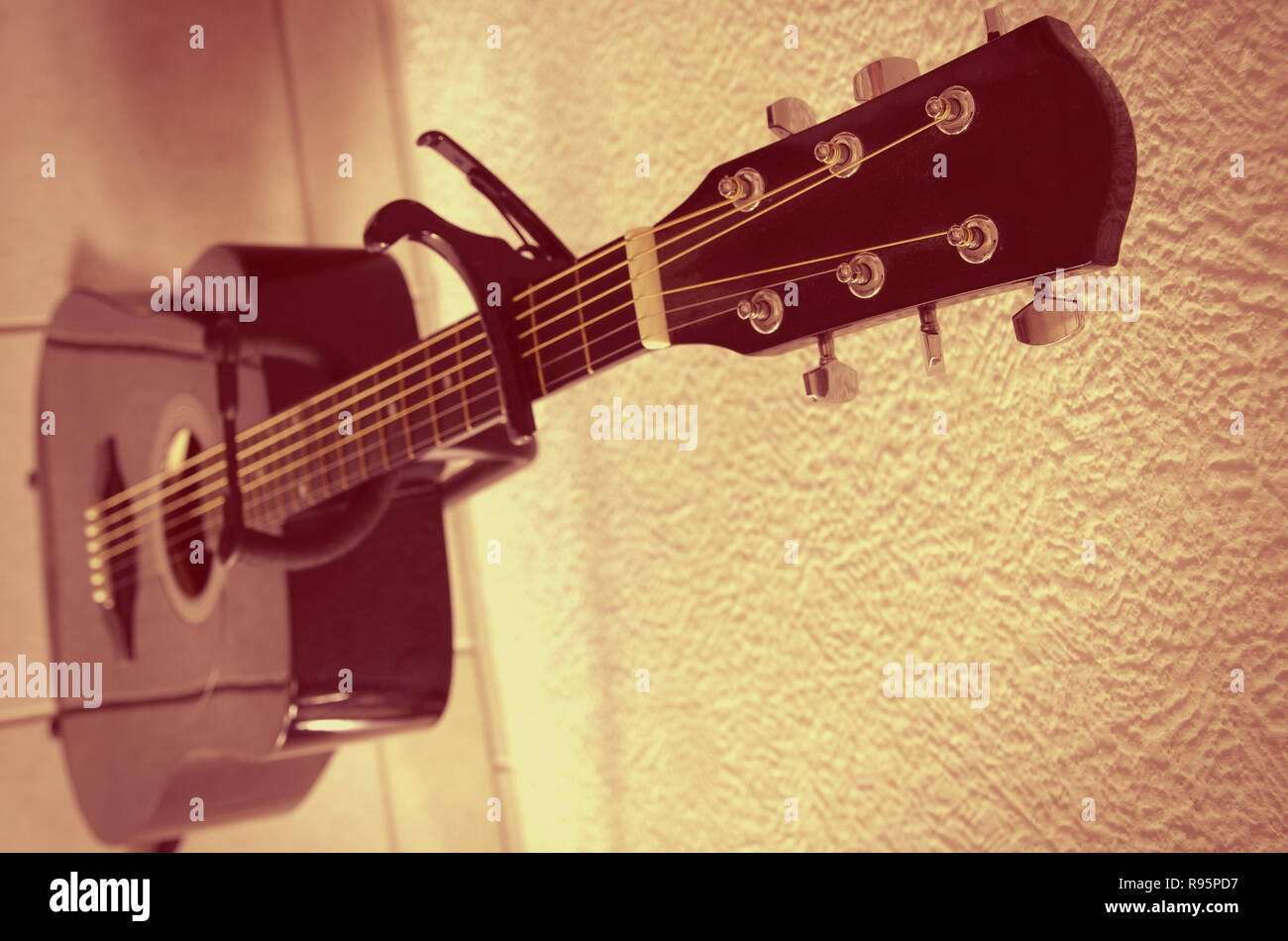 acoustic guitar with capo on a fingerboard Stock Photo
