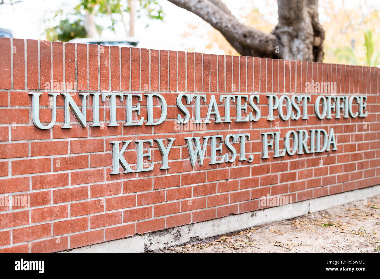 Key West, USA - May 1, 2018: United States post office sign on brick architecture outside, outdoors in park on street sidewalk in Florida keys, urban  Stock Photo