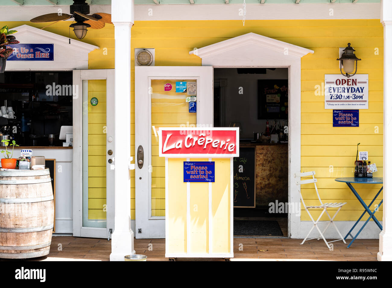 Key West, USA - May 1, 2018: La Creperie in Florida keys city on street, sidewalk with building, restaurant, cafe entrance, sign for open hours, pleas Stock Photo