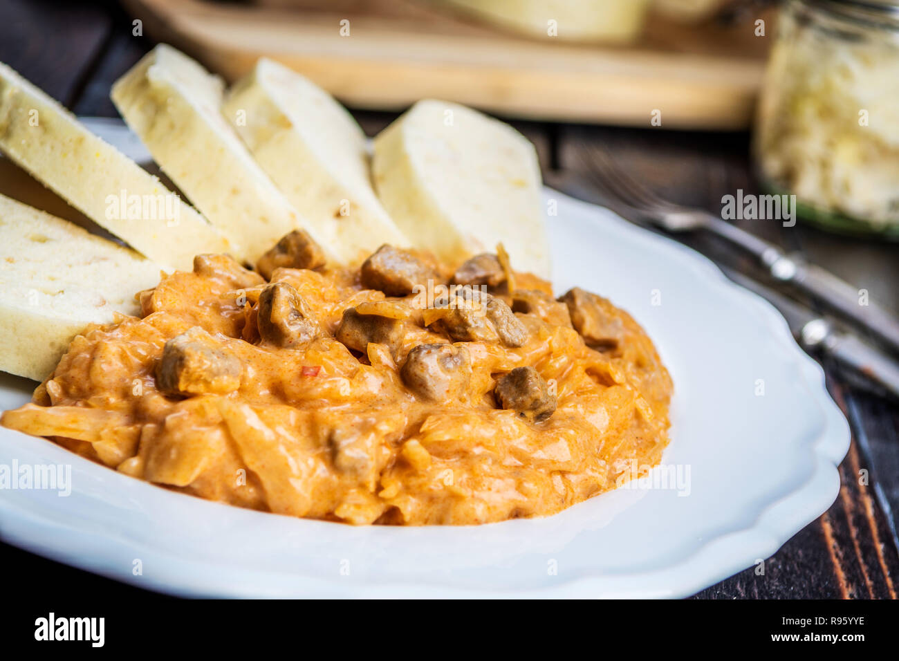 Traditional hungarian goulash (szeged gulyasz),  with pork and pickled white sauerkraut and dumplings on wood table Stock Photo