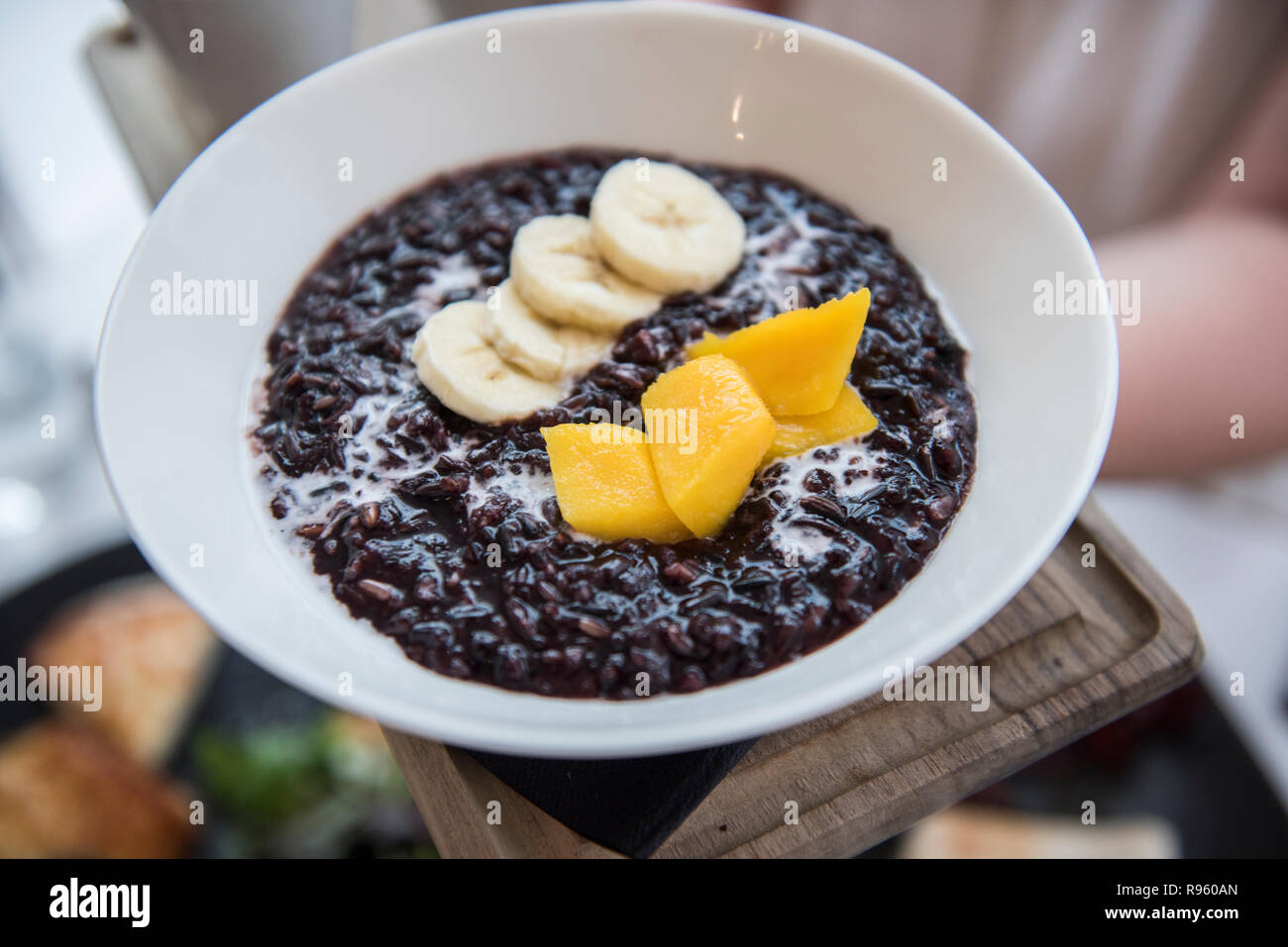 Image of very delicious and tasty black Rice With Mango and Coconut Milk seen being sold at a restaurant in Spain. The food seems to be very delicious Stock Photo