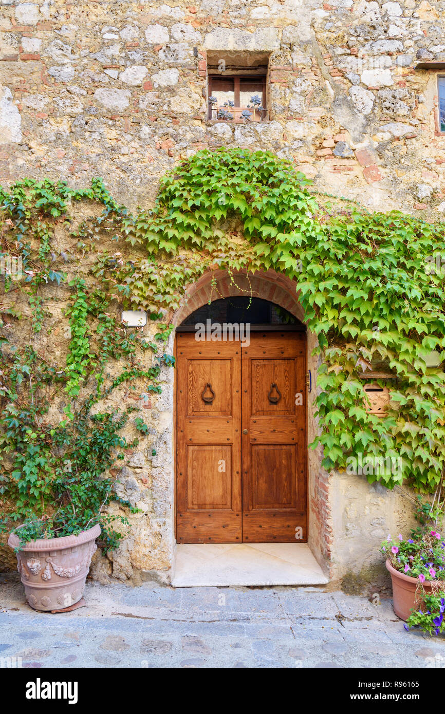Old house decorated with flowers on sunny day in Monteriggioni, Tuscany ...