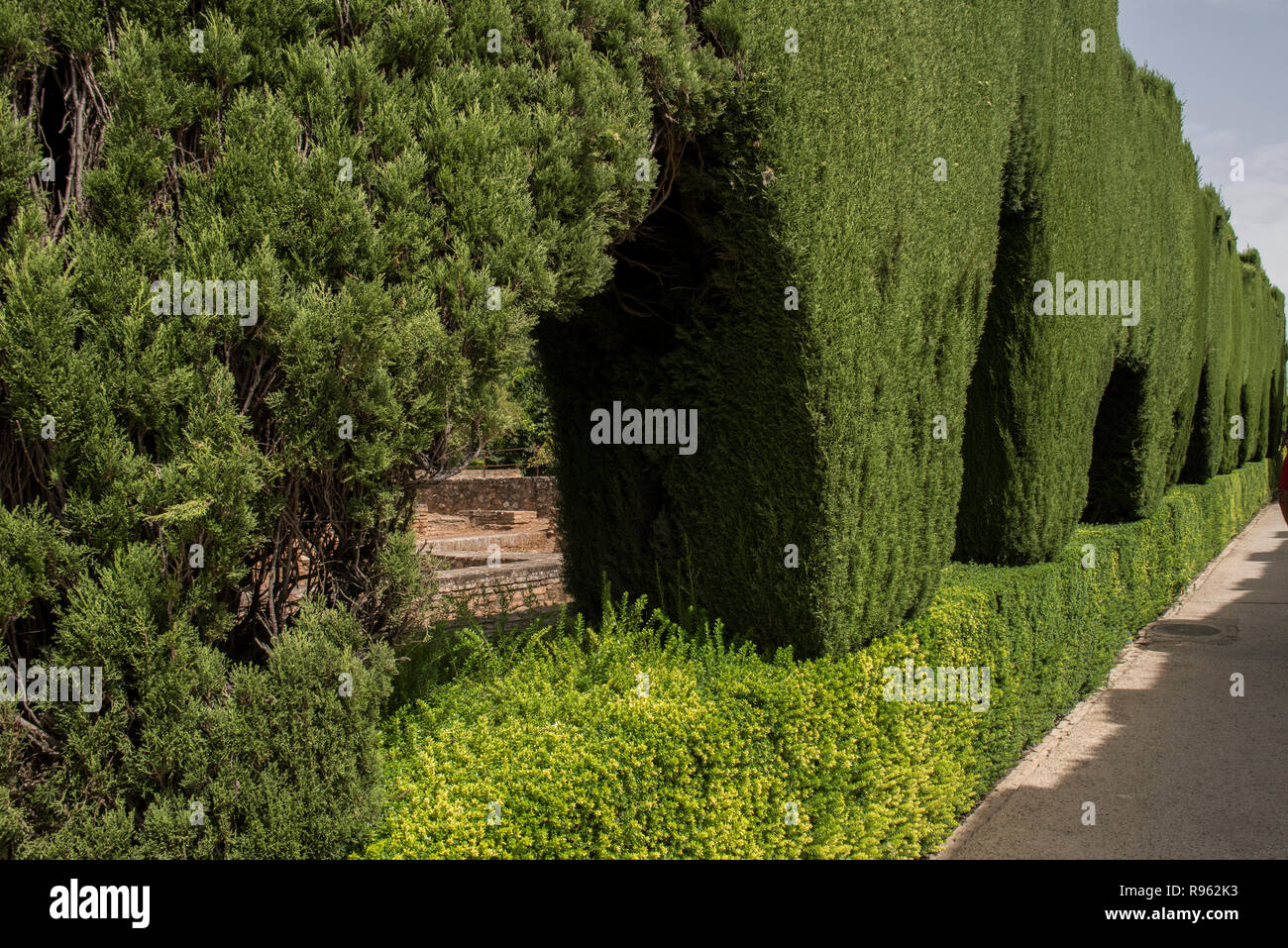 Beautiful lush green garden inside Alhambra Palace in Granada, Spain. The lush greenery looks amazing and is beautiful during the day. Alhambra Palace Stock Photo