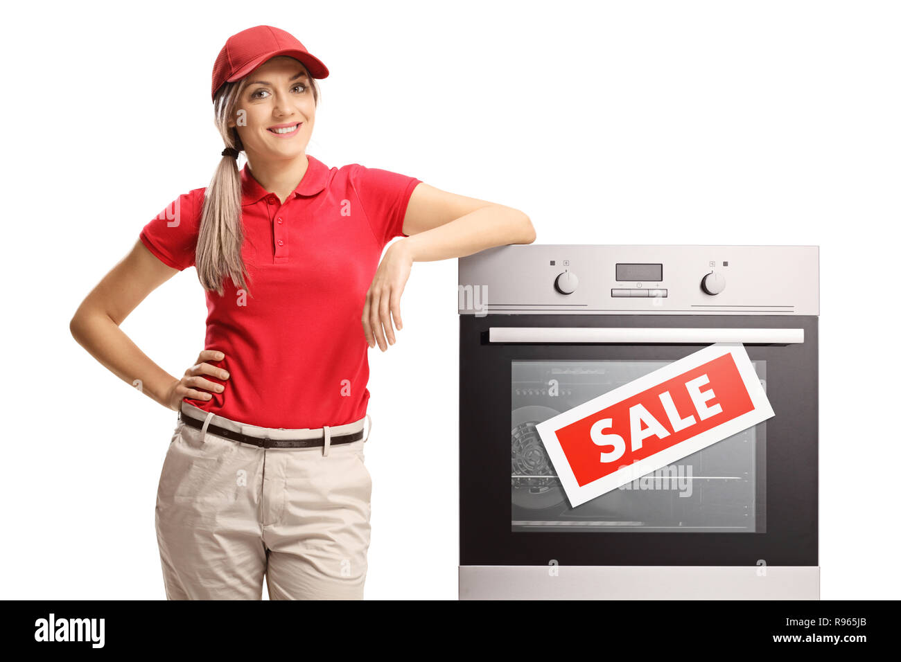 Female sales manager standing next to an electrcal oven on sale isolated on white background Stock Photo