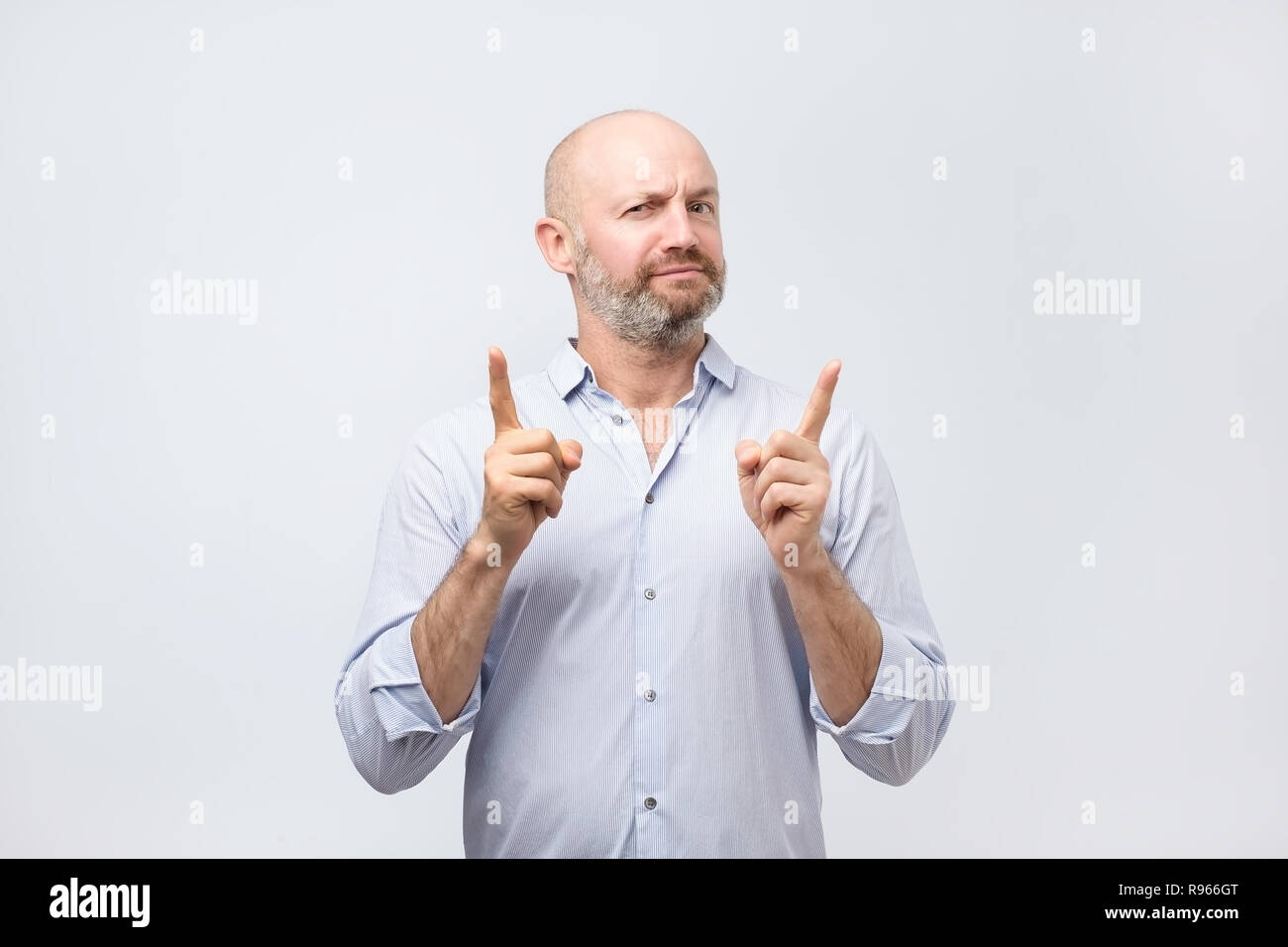 Strict mature man showing index fingers up, giving advice Stock Photo