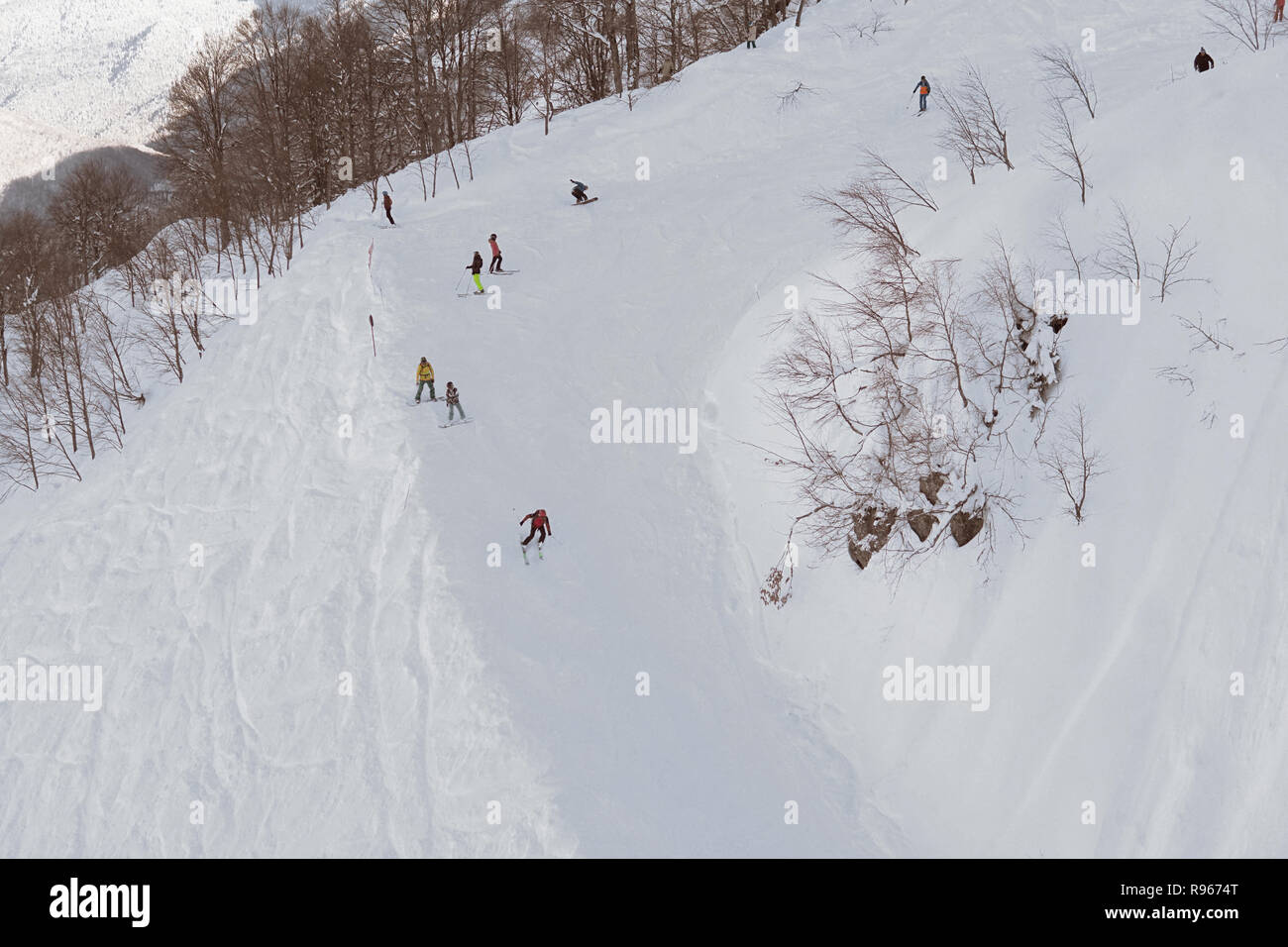 skiers and snowboarders ride on mountain slopes of the ski resort ...