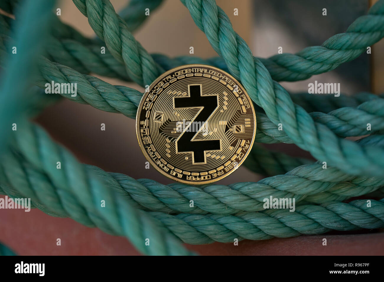 Z-Cash cryptocurrency physical coin placed between the green ropes Stock Photo