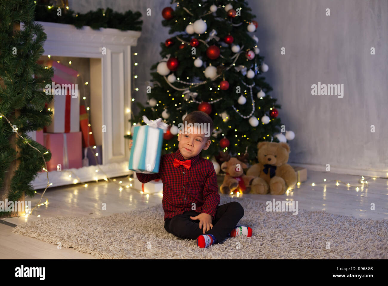 boy open up gifts from Christmas New Year holiday house Stock Photo