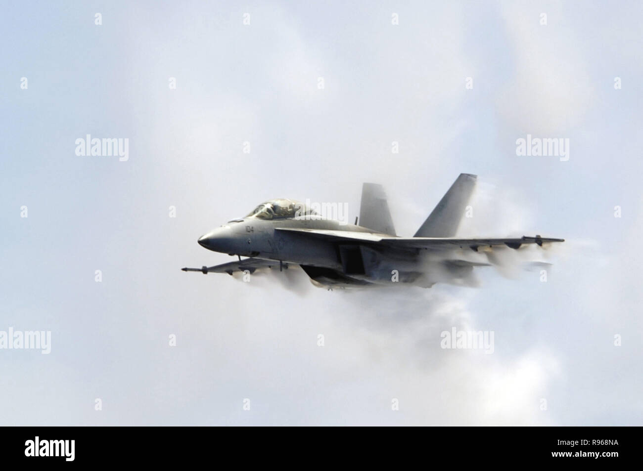 An F/A-18F Super Hornet aircraft punches through a cloud of water vapor while breaking the sound barrier during an air power demonstration over the USS Kitty Hawk (CV 63) while at sea on Aug. 23, 2007.  DoD photo by Petty Officer 3rd Class Jimmy C. Pan, U.S. Navy. Stock Photo