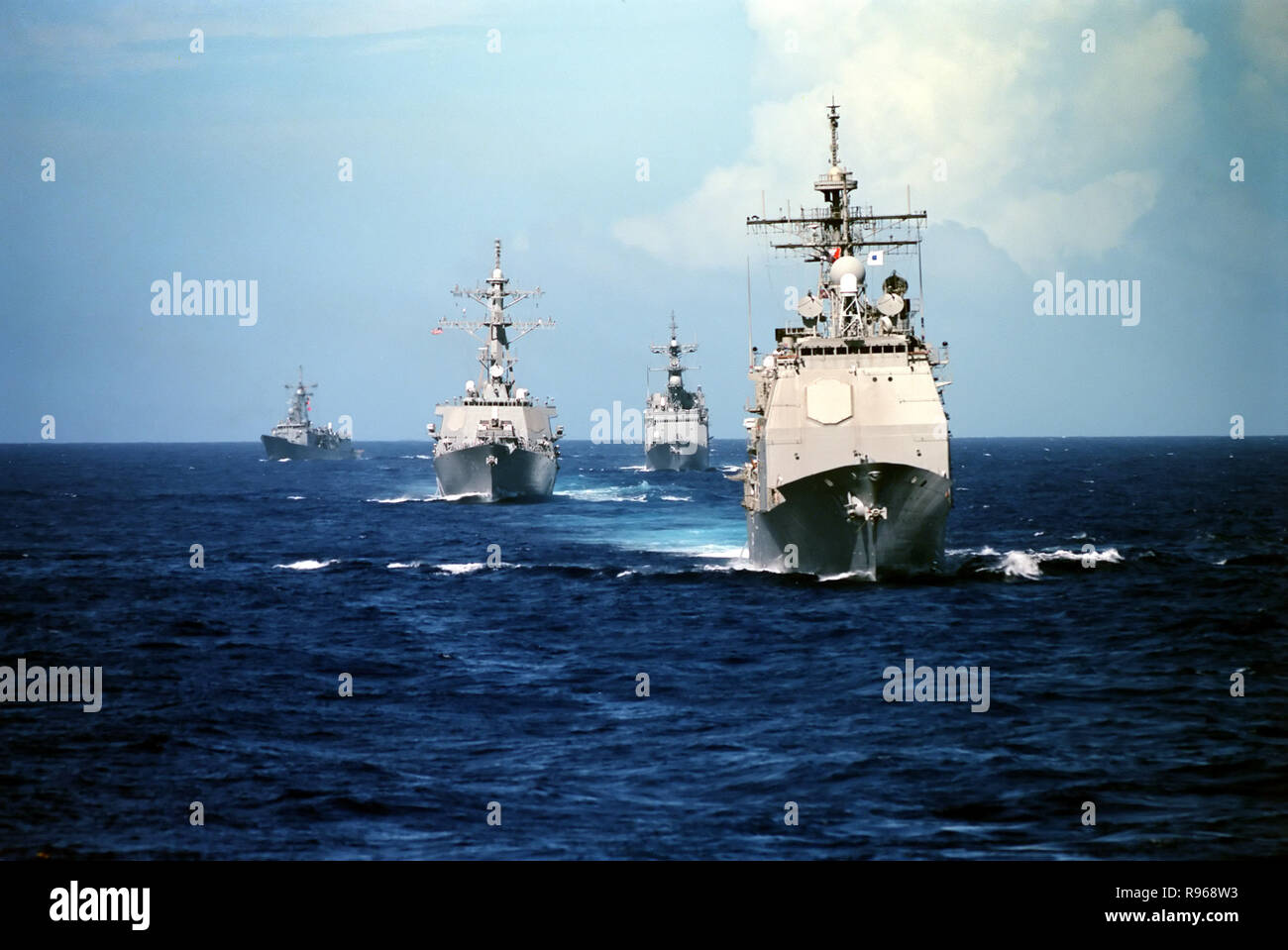 The Ticonderoga Class Guided Missile Cruiser USS Vincennes (CG 49) (right) steams in front of three other classes of U.S. Navy ships. Following the Vincennes from right to left are the Spruance Class Destroyer USS John Cushing (DD 985), Arleigh Burke Class Guided Missile Destroyer USS John S. McCain (DDG 56), and the Oliver Hazard Perry class Guided Missile Frigate USS Gary (FFG 51).   DoD photo by Petty Officer 1st Class Wade McKinnon, U.S. Navy Stock Photo