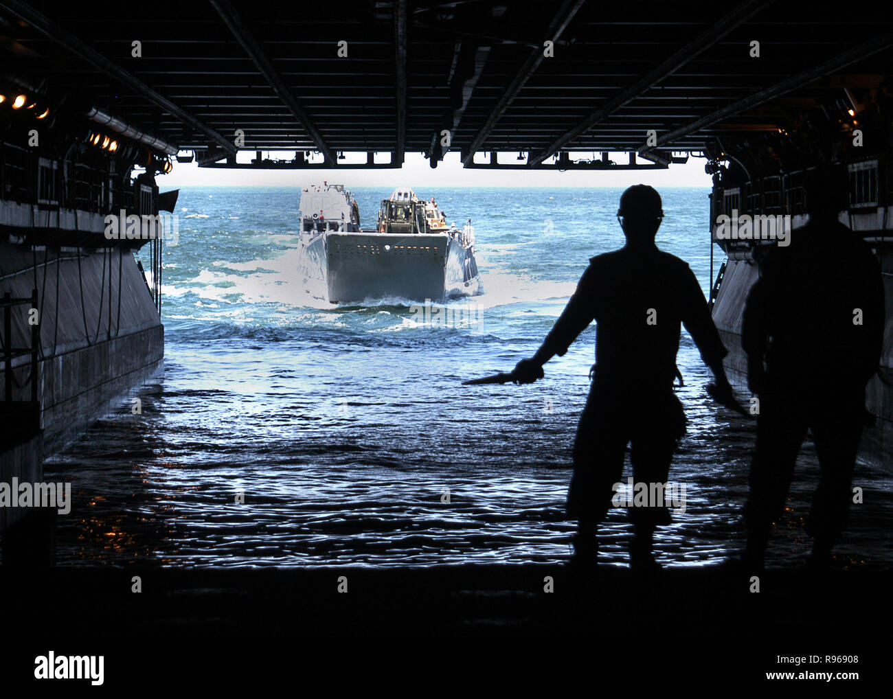 U.S. Navy sailors guide a Landing Craft Utility boat into the flooded well deck of the USS Kearsarge (LHD 3) to offload equipment and supplies as the ship operates in the Atlantic Ocean. DoD photo by Seaman Christopher Newsome, U.S. Navy Stock Photo