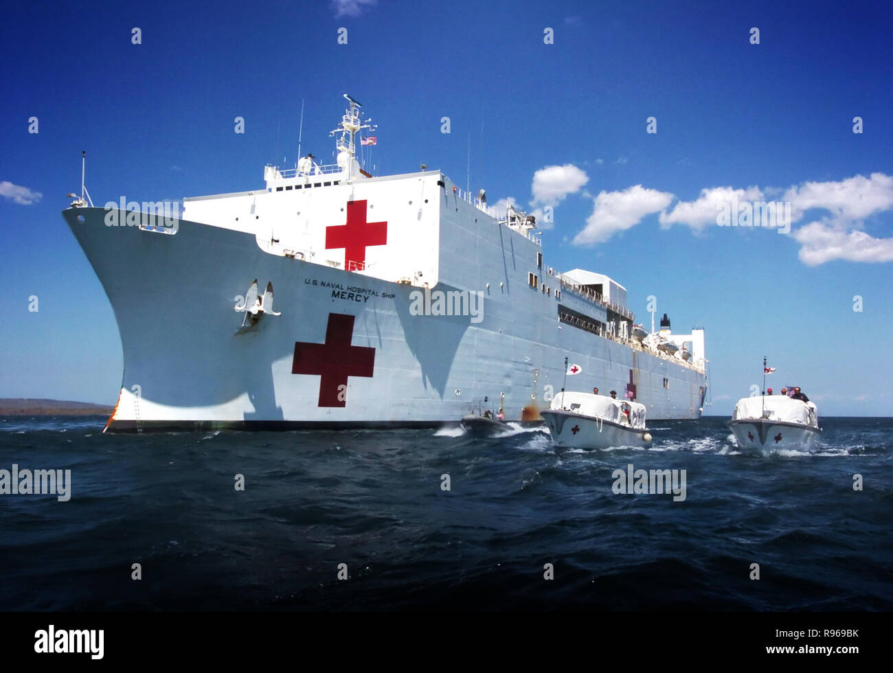 The hospital ship USNS Mercy (T AH 19) moors off the coast of the island of Kupang in West Timor, Indonesia, as Mercy's two transport boats shuttle patients and crew to and from shore.   DoD photo by Chief Petty Officer Edward G. Martens, U.S. Navy. Stock Photo