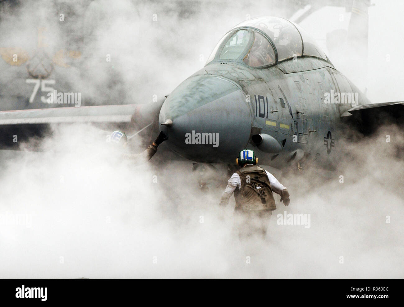 Steam from the catapult envelopes a Navy F-14 Tomcat as a flight crew prepares it for launch from the aircraft carrier USS Harry S. Truman (CVN 75)  while underway in the Persian Gulf.    DoD photo by Photographer's Mate Airman Ryan O'Connor, U.S. Navy Stock Photo