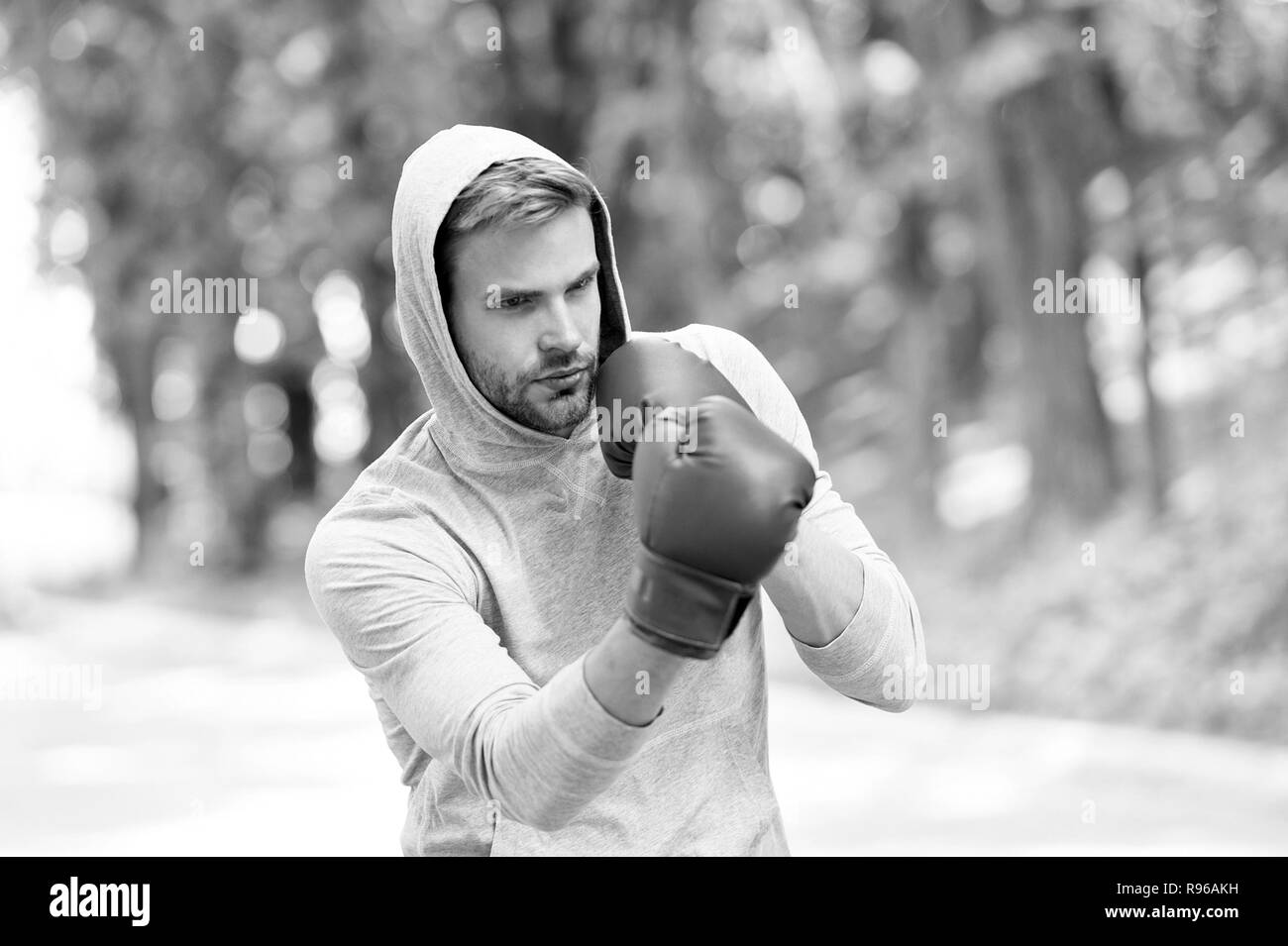 Sharpen his skill. Sportsman concentrated training boxing gloves