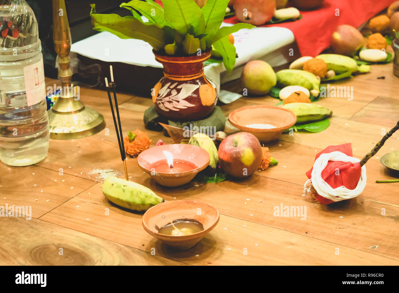 Selective focus. Diwali puja or Laxmi puja set up at home. Oil lamp or diya with crackers, sweet, dry fruits, indian currency, flowers and statue Stock Photo