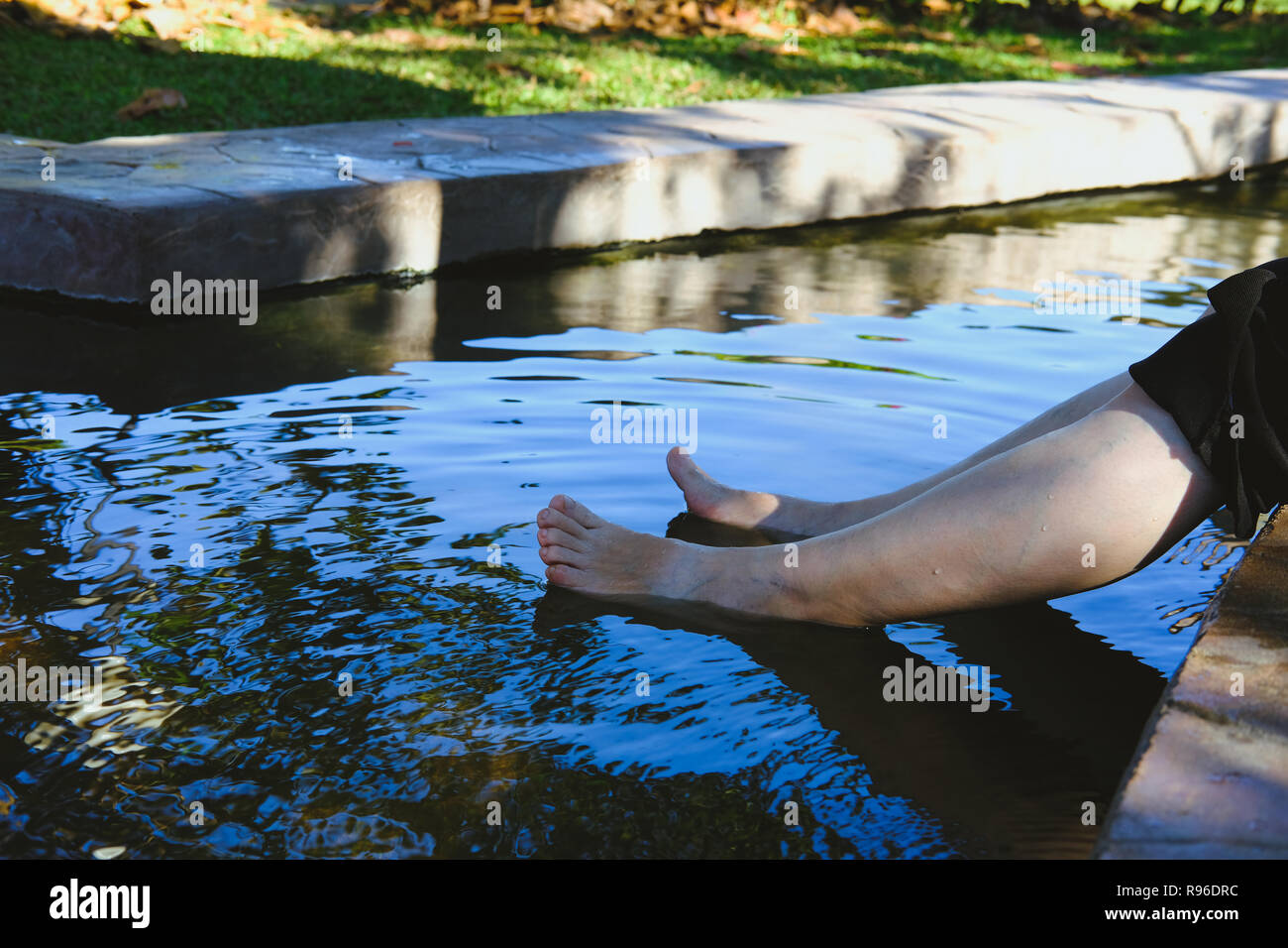 woman soaking feet in hot mineral spring water. healthy lifestyle