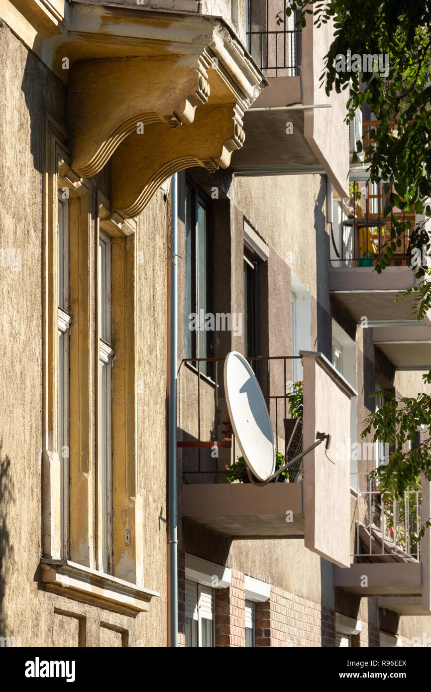 Old and modern buildings side by side. Architectural contrast, curved shapes vs. straight lines, ornamented details vs. simple plain concrete Stock Photo