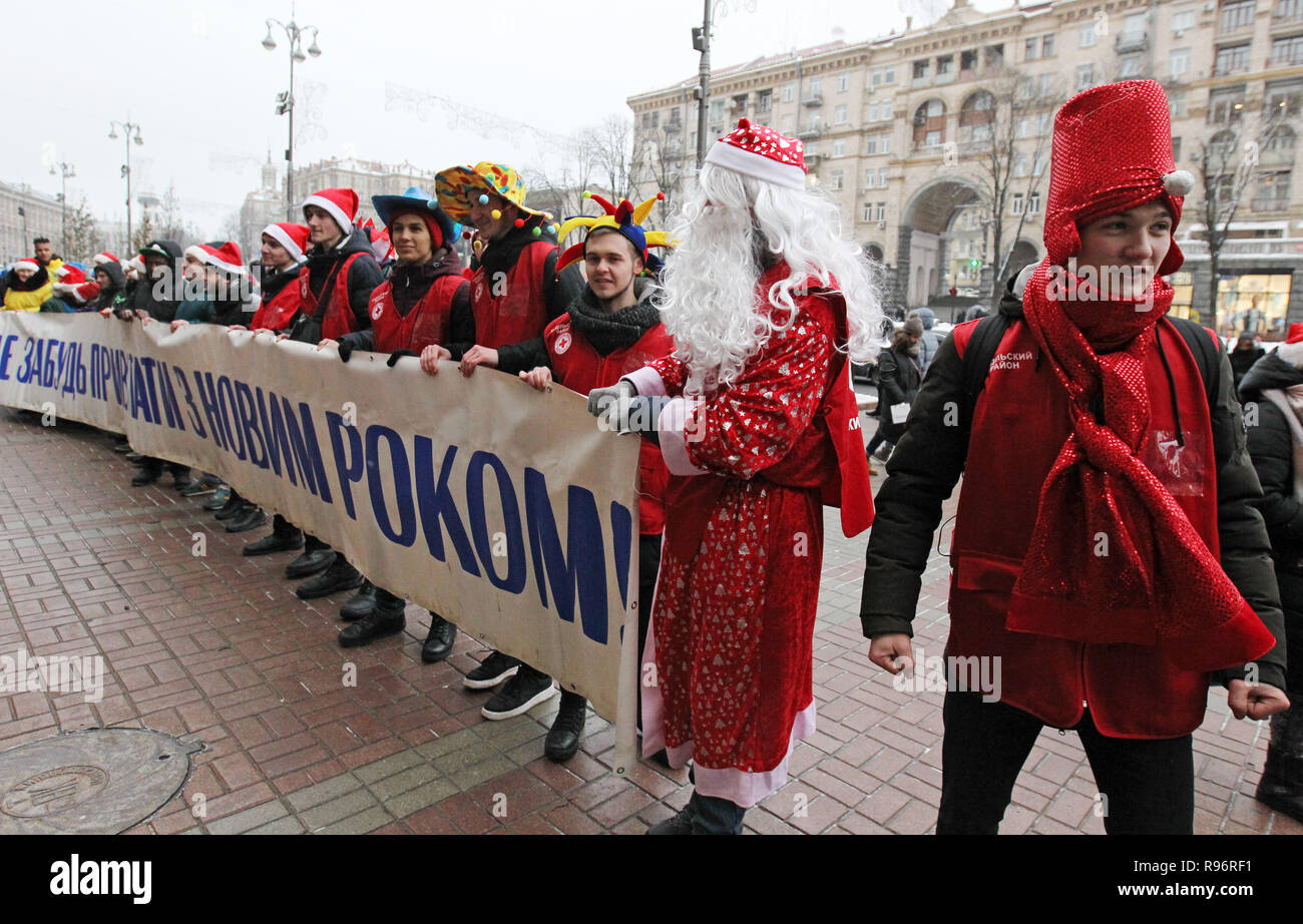 Volunteers of St. Nicholas assistants dressed in costumes are seen holding a banner during the parade. The parade is a part of the action 'Don't forget to greet!' in what volunteers wearing costumes of St. Nicholas assistants giving presents to kids from poor families, children in orphanages and hospitals. Stock Photo
