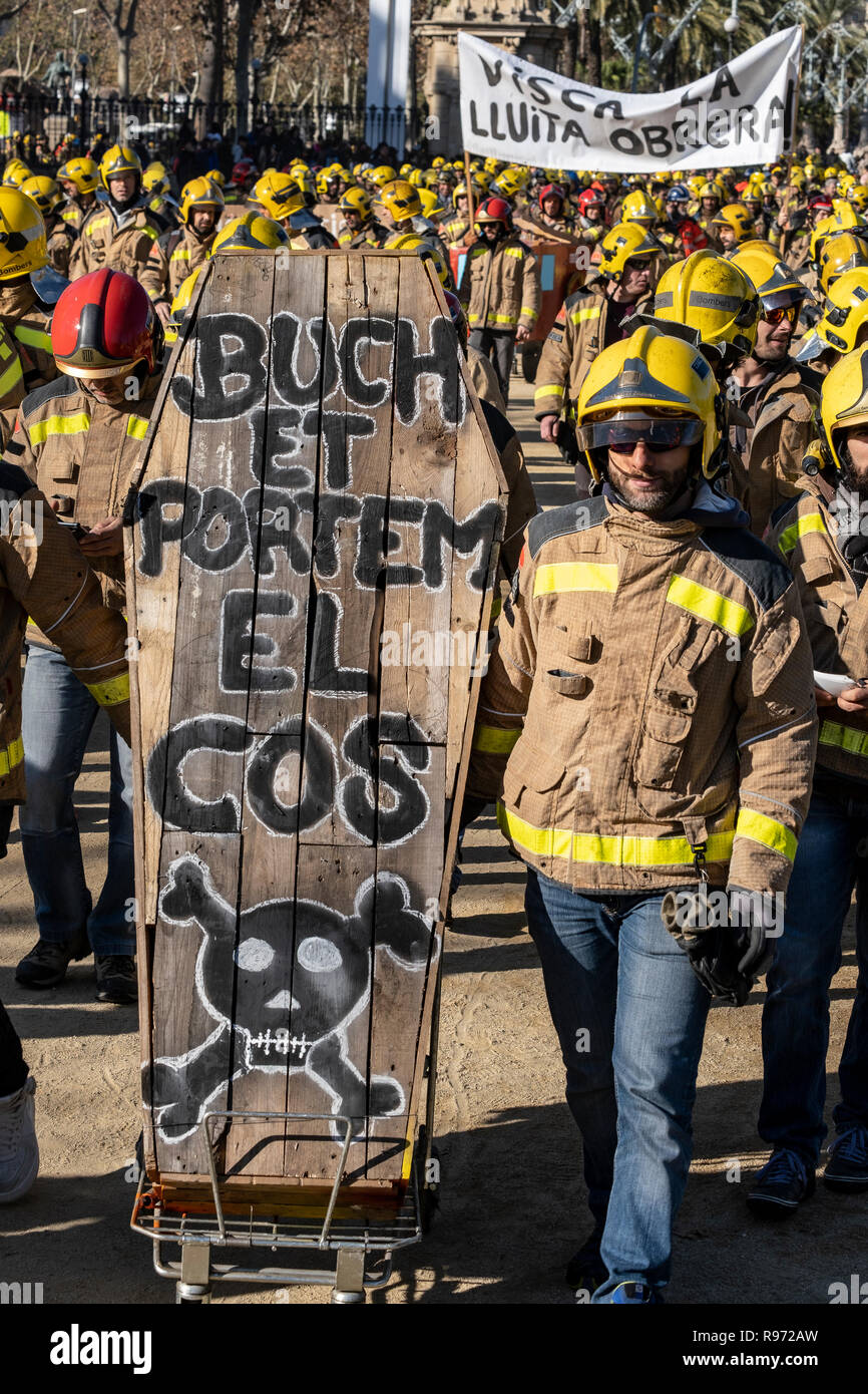 Firefighters are seen carrying a coffin during the protest. More than a hundred firefighters from the Generalitad of Catalonia have demonstrated in the center of Barcelona to end up in front of the Parliament where they have set fire to several coffins and skeletons in reference to the deficient material with which they are forced to work due to a scarce budget. Stock Photo