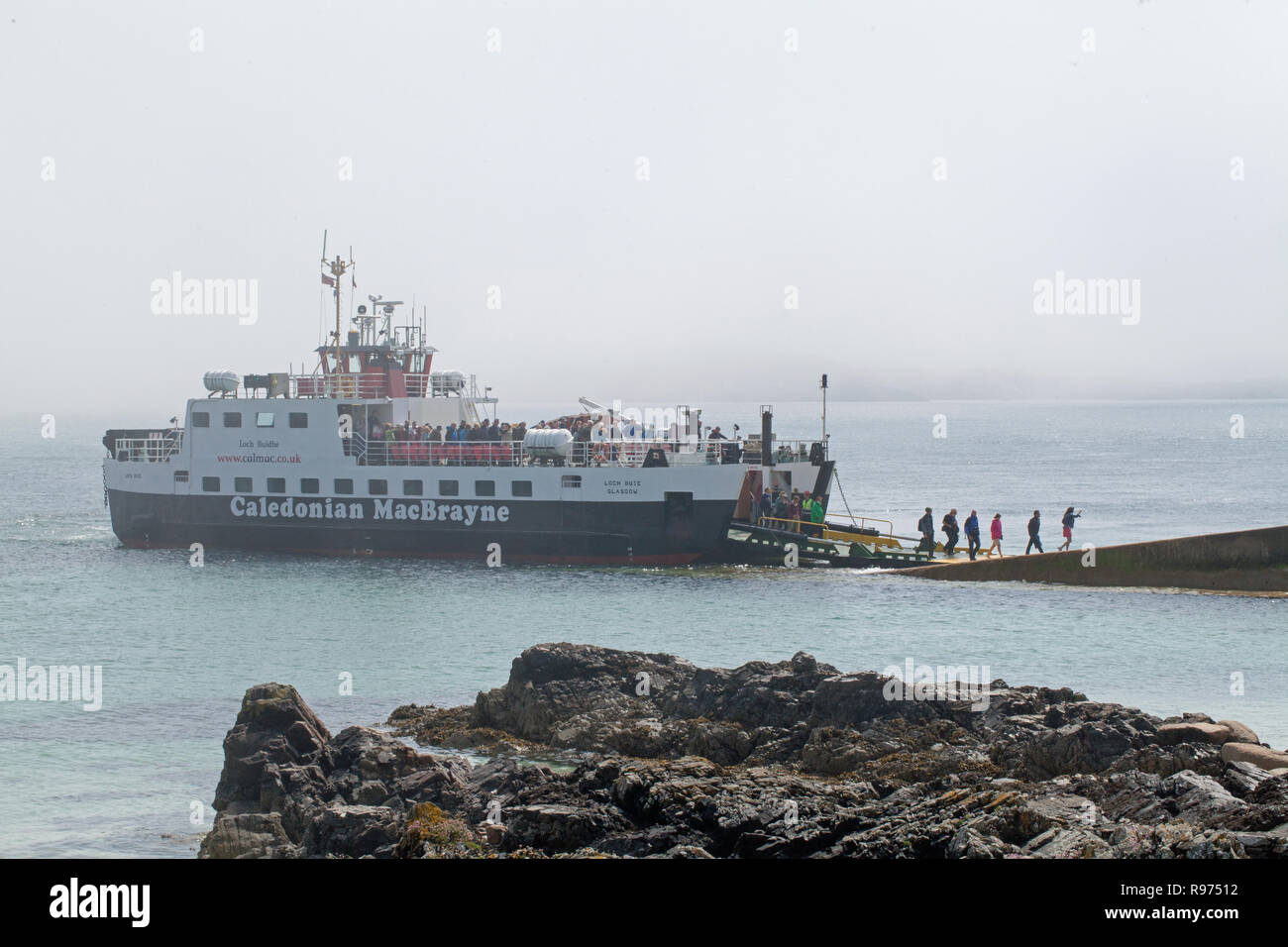 First-foot passengers of the day, arriving from Fionnphort, Mull, disembarking Quayside St. Ronan’s Bay, Isle of Iona. The Inner Hebrides, Argyll and Bute, West Coast of Scotland. The UK. Stock Photo