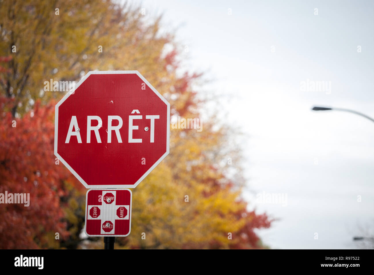 Quebec Stop Sign, obeying by bilingual rules of the province imposing the use of French language on roadsigns, thus translated Stop into Arret, taken  Stock Photo