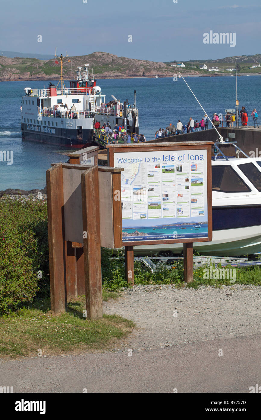 Foot passengers, return departing from Iona, for the ferry to Fionnphort, Mull on the horizon. The Quayside, The Pier, Port Ronain’s Bay, Isle of Iona. Inner Hebrides, West Coast Scotland. Stock Photo