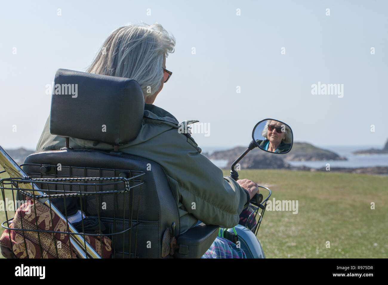 Mobility Buggy enabling disabled, ​or physically impaired senior citizen, a ​holiday visitor, to access and explore the Isle of Iona. West coast of Scotland.​ Stock Photo