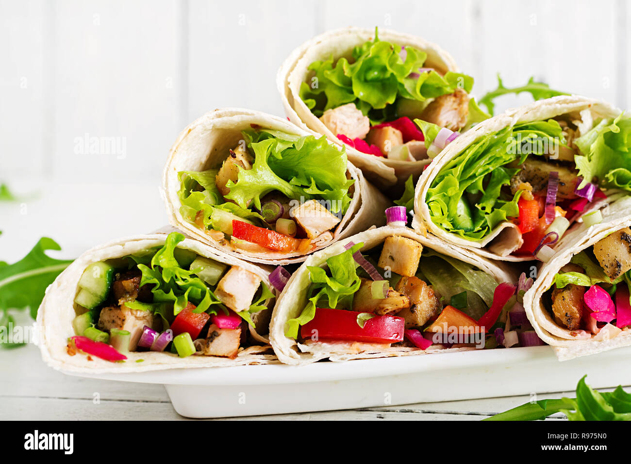 Chicken burrito. Healthy lunch.  Mexican street food fajita tortilla wraps with grilled  chicken fillet and fresh vegetables. Stock Photo