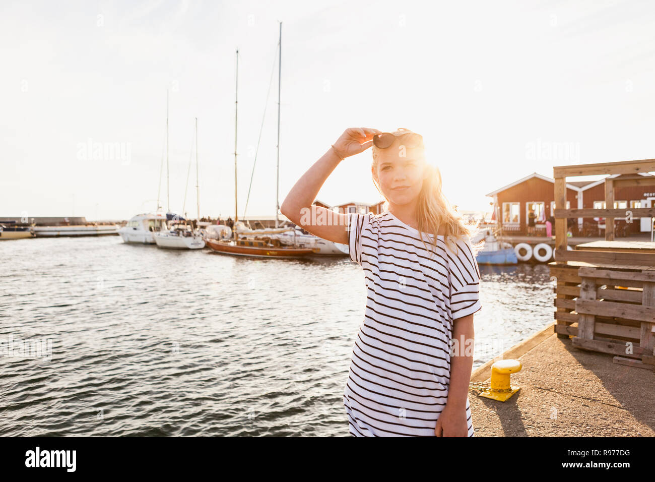 Teenage girl standing at the harbor in Hano, Sweden Stock Photo