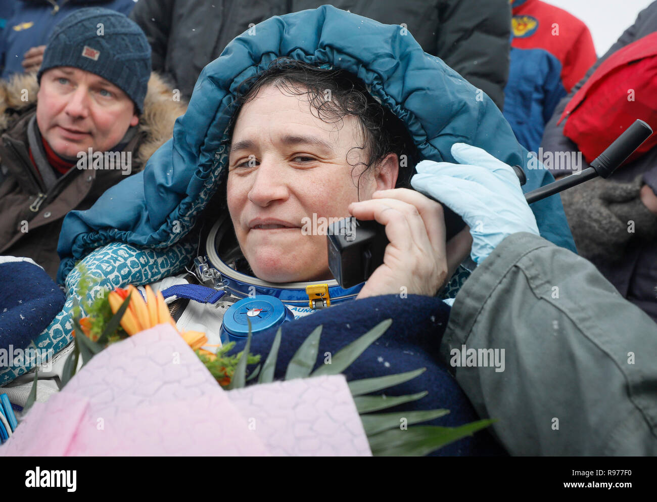 NASA's Serena Aunon-Chancellor speaks on a satellite phone after landing in a remote area outside the town of Zhezkazgan, formerly known as Dzhezkazgan, Kazakhstan, on Thursday, Dec. 20, 2018. Three astronauts have returned to Earth after more than six months aboard the International Space Station. (Shamil Zhumatov/Pool via AP) Stock Photo