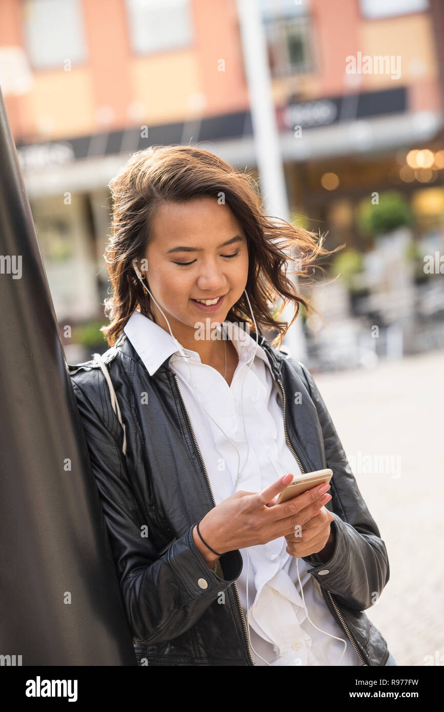 Young woman looking at her cell phone in Solvesborg, Sweden Stock Photo