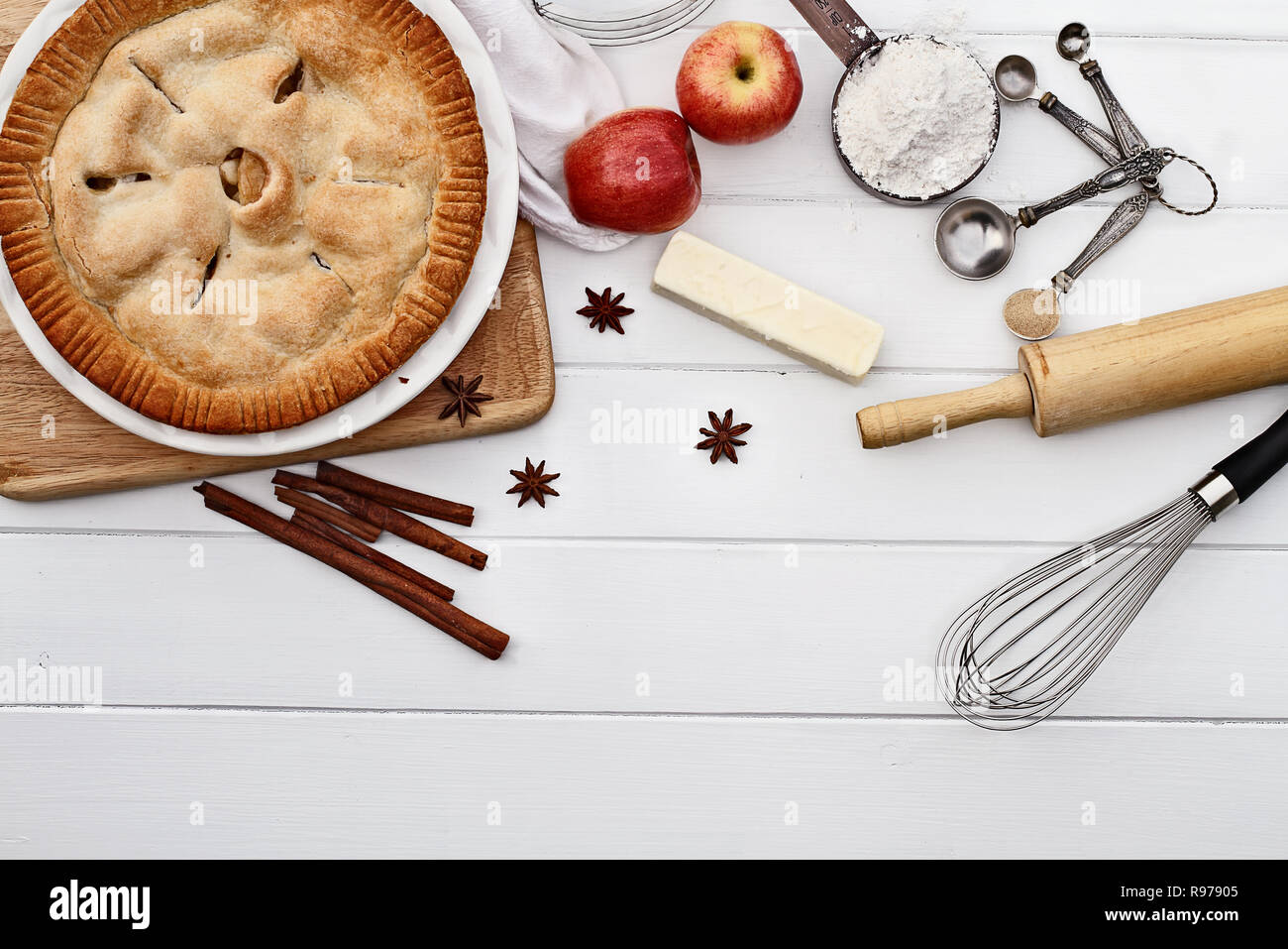 Homemade apple pie dessert and ingredients shot from overhead over a white wooden table top with room for copy space. Stock Photo