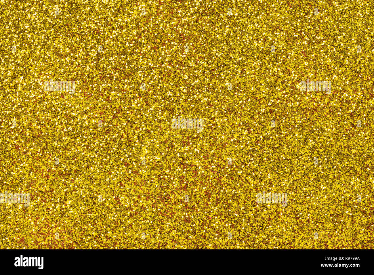 Golden sparkling background from small sequins, closeup. Brilliant