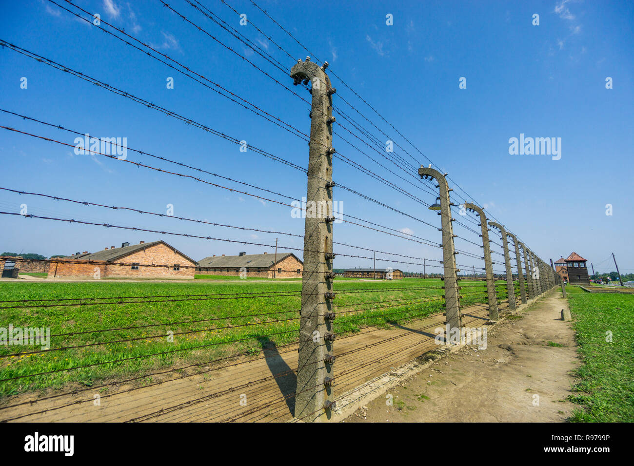 Fence and watchtower surrounding residential buildings in Auschwitz-Birkenau concentration camp used by Nazis during World War II, Poland Stock Photo