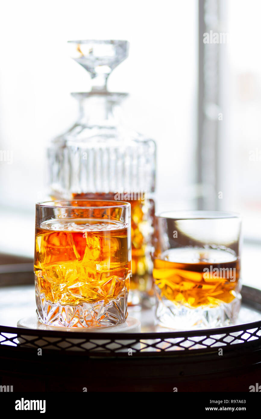 Whiskey in a tumbler alongside a cut glass decanter Stock Photo