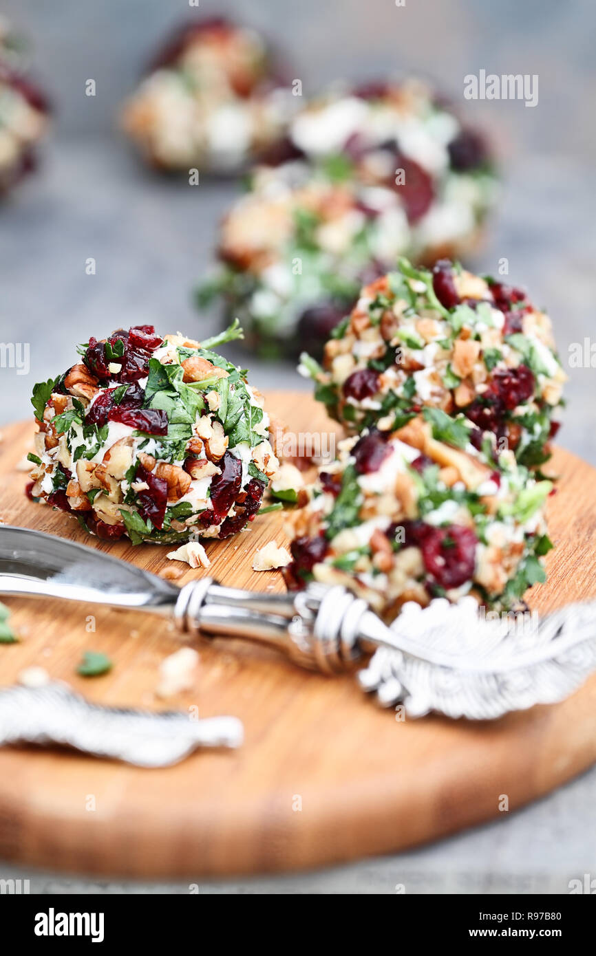 Cranberry nut cheese ball made with cream cheese, goat or feta cheese, parsley, cranberries and chopped pecans over a rustic background. Extreme shall Stock Photo