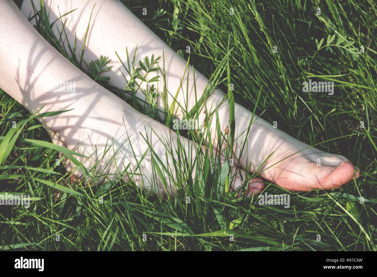 Legs of the girl with very light skin and with natural nails on toes close-up. Stock Photo