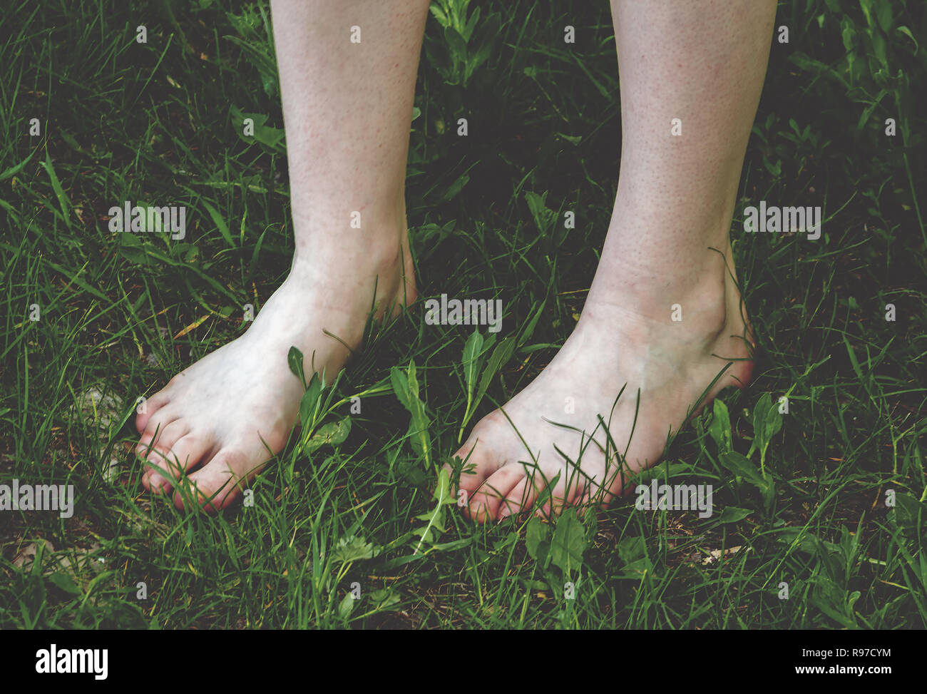 Shaved legs of the girl with very light skin and natural nails on the toes close-up. Stock Photo