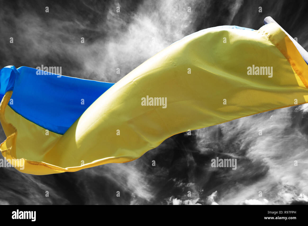 Sunlight Ukrainian flag waving in wind on black and white storm sky Stock Photo