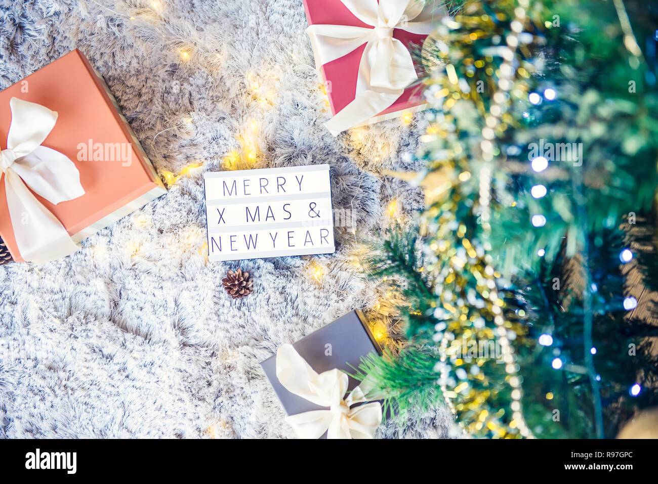 Top View Composition Of Lighted Box With Merry Christmas And New Year Wishes And Presents In Colorful Festive Wrapping Tied With Bow Under Xsmas Tree Stock Photo Alamy